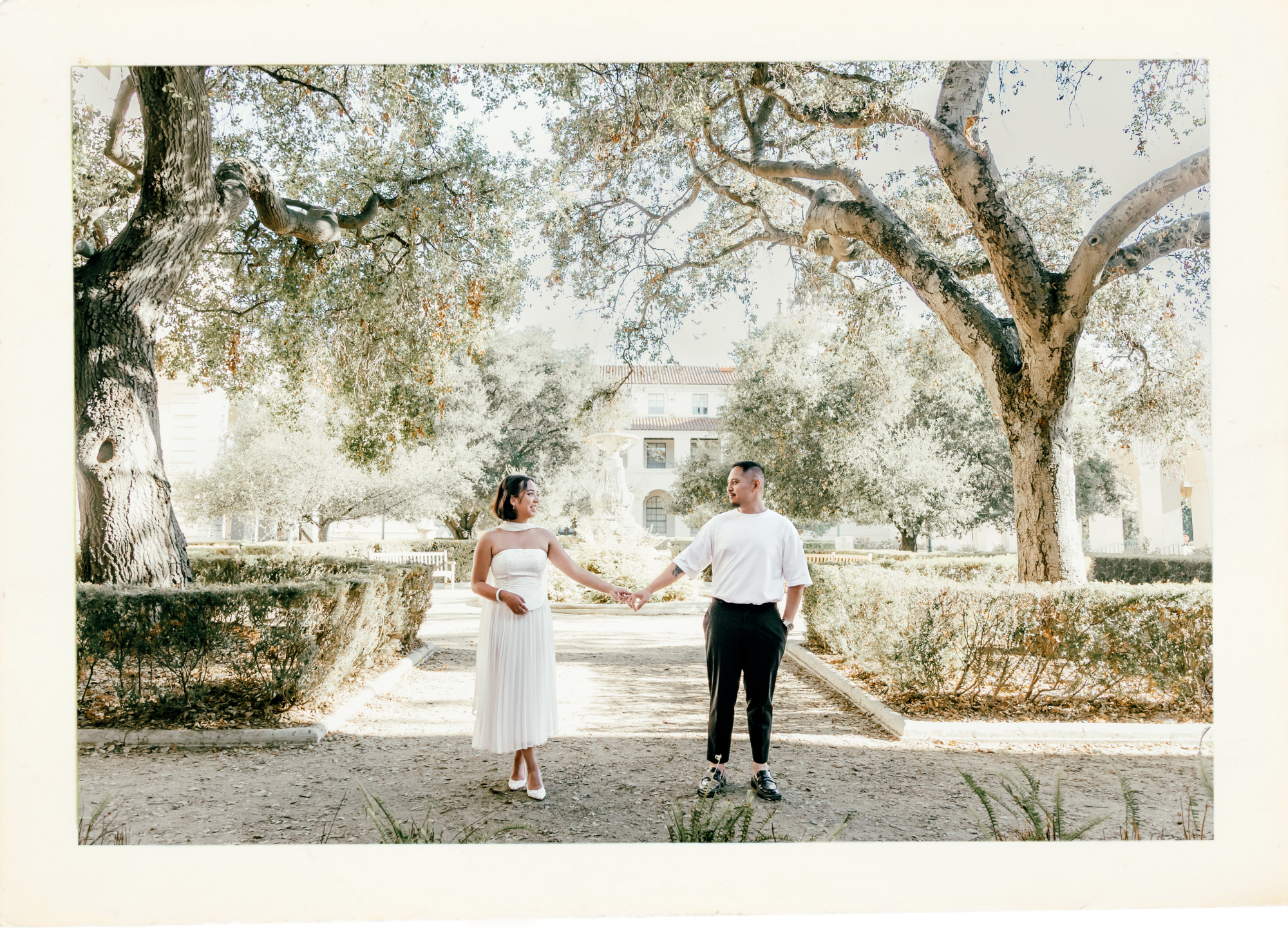 Jyselle and Kyle holding hands under the trees, celebrating their engagement